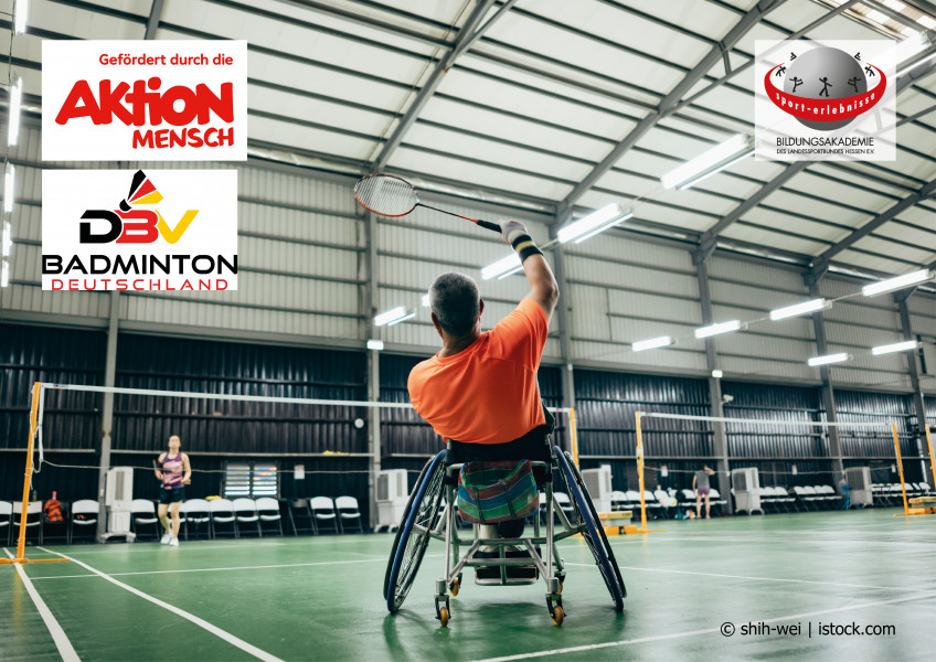 Ein Mensch sitzt im Rollstuhl und spielt in einer Halle Badminton über ein Netz. Ihm gegenüber steht eine Person ohne Behinderung. Inklusion im Sport.